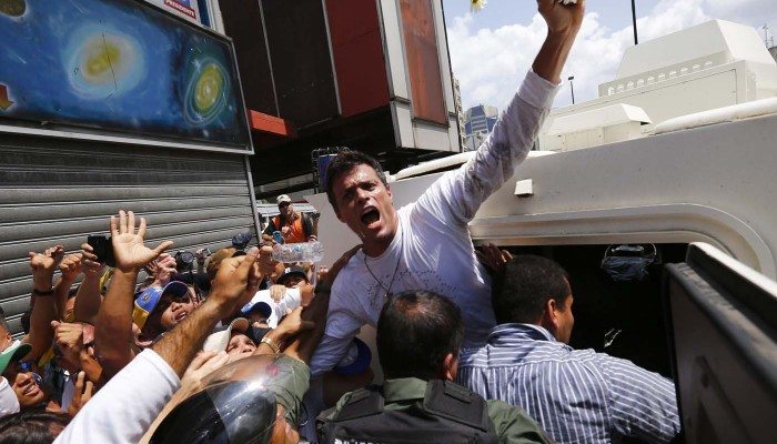 Venezuelan opposition leader Leopoldo Lopez gets into a National Guard armored vehicle in Caracas February 18, 2014. Lopez, wanted on charges of fomenting deadly violence, handed himself over to security forces on Tuesday, Reuters witnesses said. Lopez, a 42-year-old U.S.-educated economist who has spearheaded a recent wave of protests in Venezuela, got into an armored vehicle after giving a speech to an opposition rally in Caracas. REUTERS/Jorge Silva (VENEZUELA - Tags: POLITICS CIVIL UNREST)