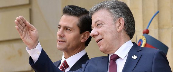 Mexican President Enrique Pena Nieto (L) listens to Colombian President Juan Manuel Santos at Narino presidential palace in Bogota, on October 27, 2016. Pena Nieto will attend the XXV Ibero-American Summit to be held between Friday and Saturday in Cartagena de Indias. / AFP PHOTO / GUILLERMO LEGARIA
